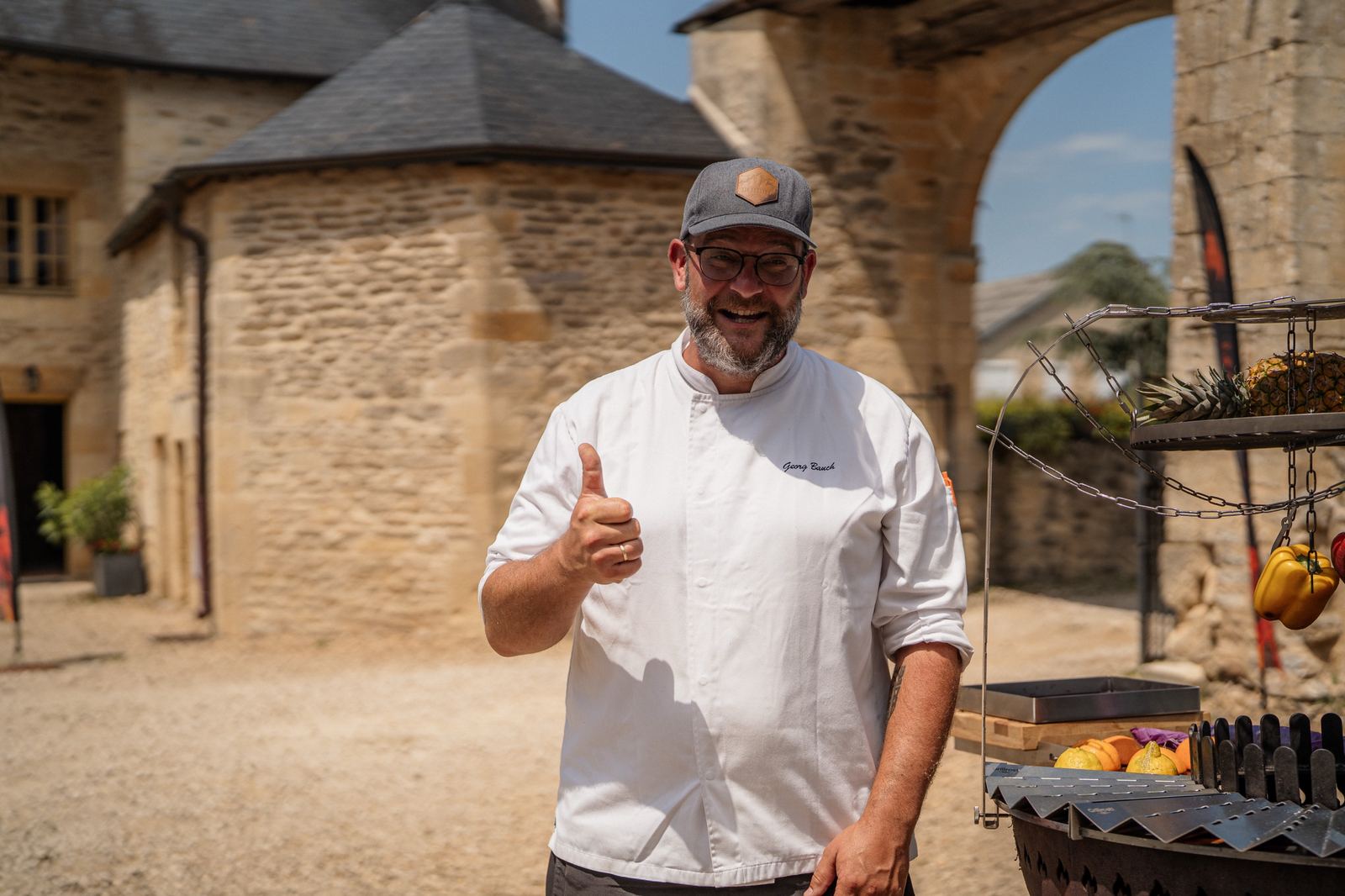 Georg Bauch at an open fire grill in a French château courtyard